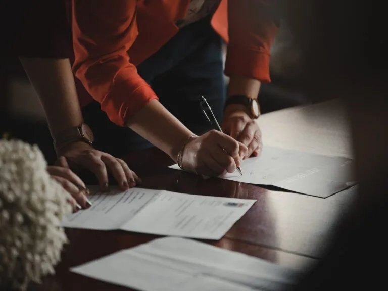 two people signing legal documents